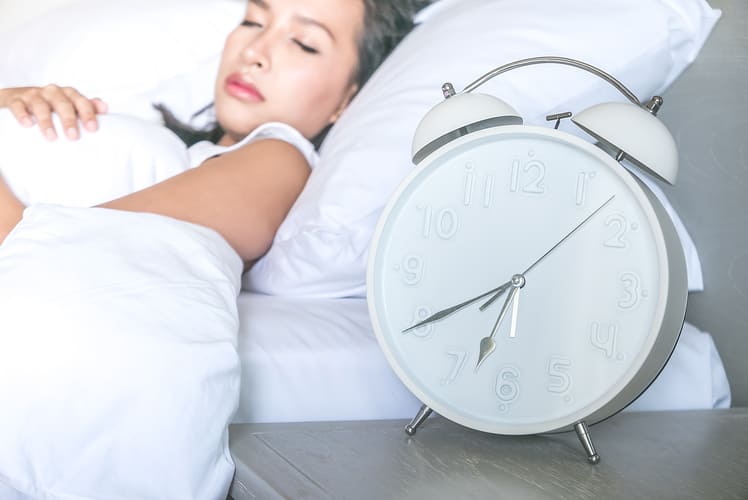close-up-clock-with-womansleeping